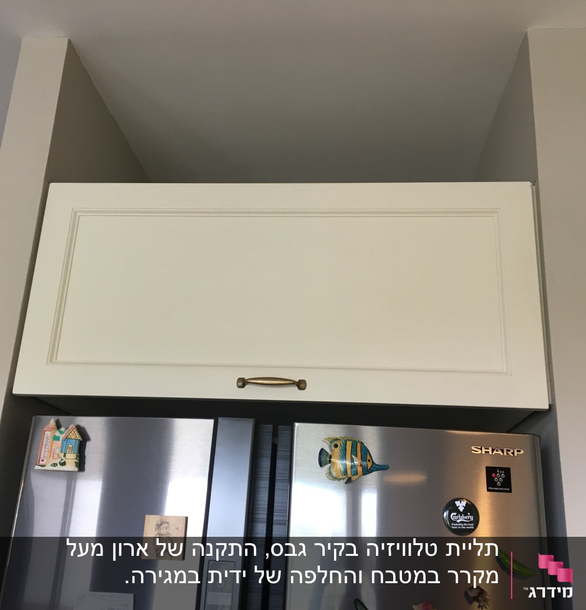 ארון מטבח מעל מקרר עם ידית זהב